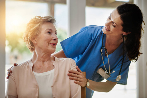Je v dobrých rukou. usmívající se starší žena hovořící se zdravotní sestrou v zařízení pro asistované žití - Fotografie, Obrázek