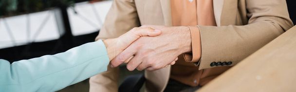 visão cortada de parceiros de negócios bem sucedidos apertando as mãos no escritório, banner - Foto, Imagem
