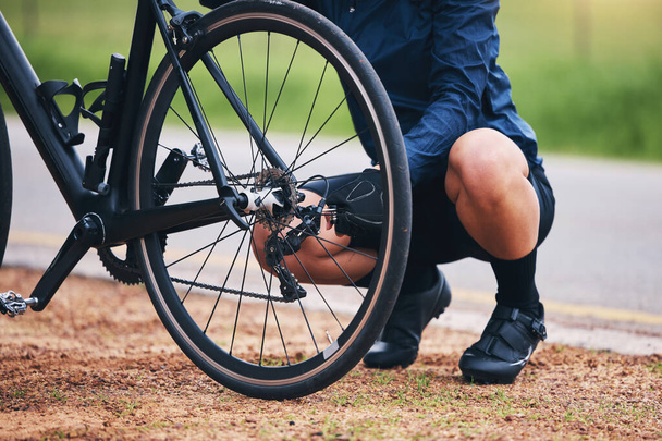 Person, bike and wheel repair outdoor for training, triathlon sports and transportation problem. Closeup of athlete, bicycle and check tire chain for travel safety, cycling maintenance and fixing hub. - Fotó, kép