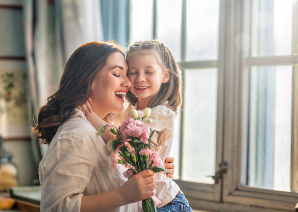 Happy mother's day. Child daughter congratulating her mother and giving her bouquet of flowers. - Foto, Imagen