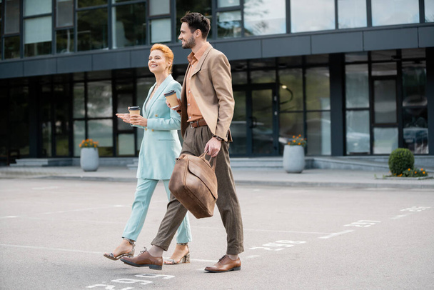 gestionnaires réussis en costumes à la mode marchant avec du café pour aller dans la rue urbaine - Photo, image