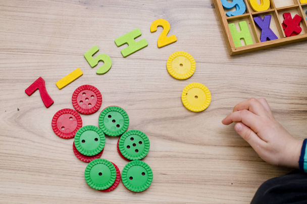 Math with fun. Counting and marking large buttons with colored numbers of natural wood. DIY game. Play at home. Learning method. Early education, counting game, fine motor skills. - 写真・画像