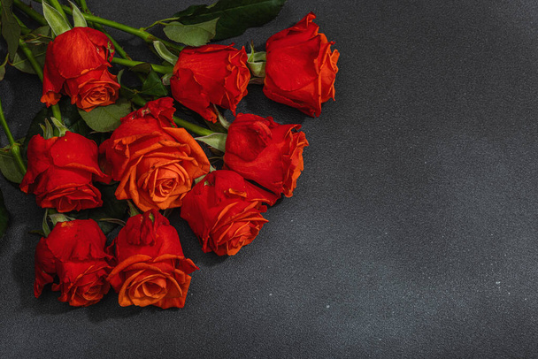 Bouquet of fresh bright roses on dark stone concrete background. Romantic gift concept, greeting card. Valentines, Woman's or Mothers Day. Wedding, Anniversary, Birthday, flat lay, top view - Foto, Imagem