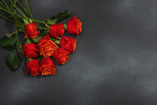 Bouquet of fresh bright roses on dark stone concrete background. Romantic gift concept, greeting card. Valentines, Woman's or Mothers Day. Wedding, Anniversary, Birthday, flat lay, top view - Foto, afbeelding