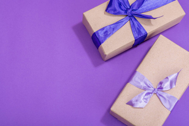 Concepto de regalo cero residuos. Envuelto en caja sorpresa de papel artesanal para Aniversario, Madres o San Valentín. Tarjeta de felicitación de cumpleaños feliz, fondo púrpura, cama plana, vista superior - Foto, imagen