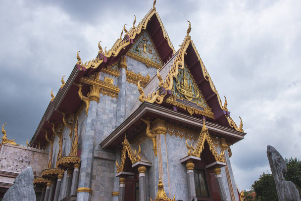 Thai style church in northeastern Thailand with rain clouds on the background. - Foto, imagen