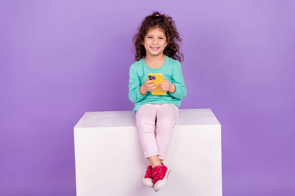 Photo of sweet cute little child dressed teal shirt chatting instagram twitter telegram facebook empty space isolated purple color background. - Фото, изображение