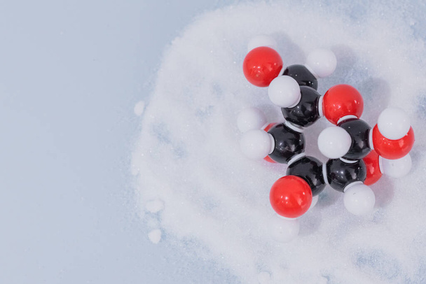 Izolovaná molekula glukózy vytvořená molekulárním modelem na bílém cukru. C6H12O6 cukr chemický vzorec s barevnými atomy a vazby - Fotografie, Obrázek