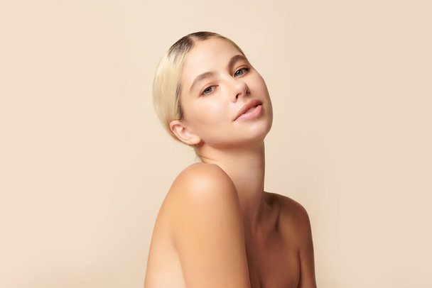 Mooie jonge vrouw met schone, frisse huid op beige achtergrond, Gezichtsverzorging, Gezichtsbehandeling, Cosmetologie, Schoonheid en spa, - Foto, afbeelding