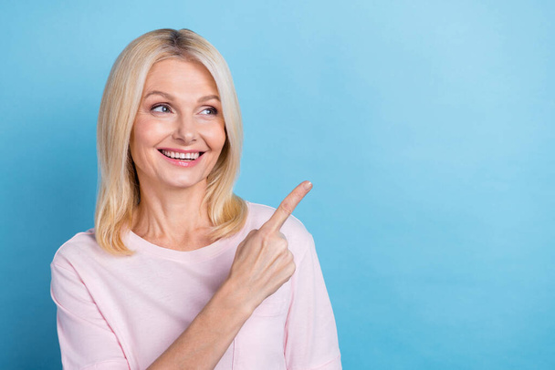 Portrait of pretty aged lady beaming smile look direct finger empty space isolated on blue color background. - Foto, Imagem