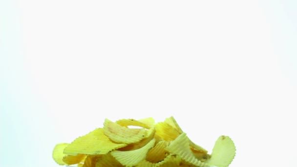 Des chips jaunes ondulées appétissantes tournent sur fond blanc
 - Séquence, vidéo