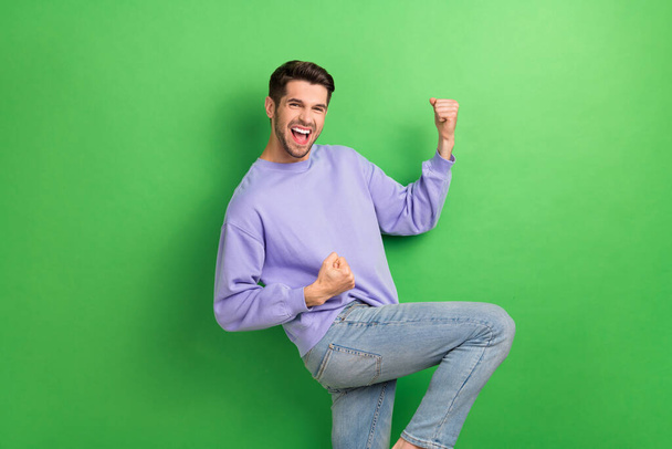 Profile portrait of funky overjoyed person raise fists shout yes isolated on green color background. - Foto, Imagem
