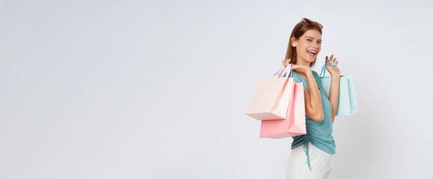 白い背景に孤立したショッピングバッグを持つ若い女性の肖像画. - 写真・画像