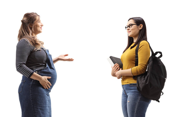 Profile shot of a pregnant woman talking to a female student isolated on white background - Fotó, kép