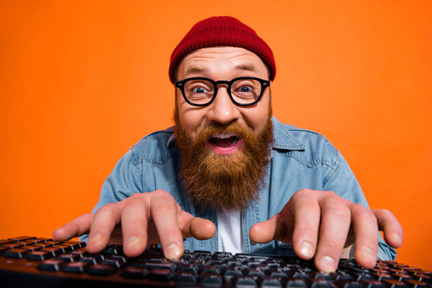 Portrait of excited young guy working on computer typing writing emails letters isolated on bright color background. - Foto, immagini