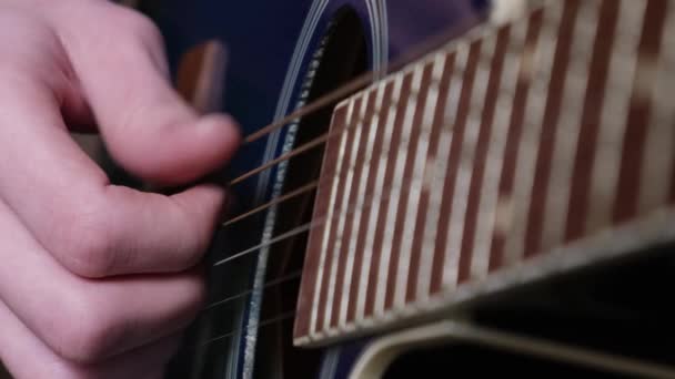 Egy göndör, vörös hajú, amerikai külsejű fiú tanul gitározni. Gitáros kéz közelről. Oktatás és hobbik. - Felvétel, videó