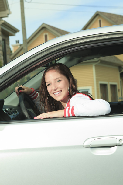 Car driver woman happy showing car keys out window - Foto, immagini