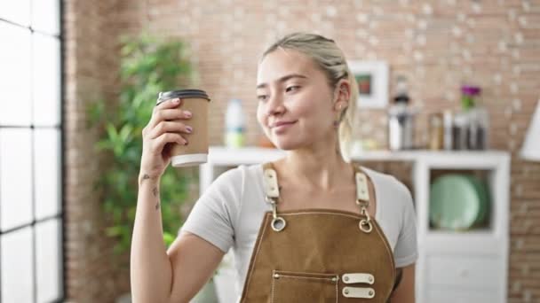 Mladá krásná hispánská žena nosí zástěru drží odnést kávu v jídelně - Záběry, video