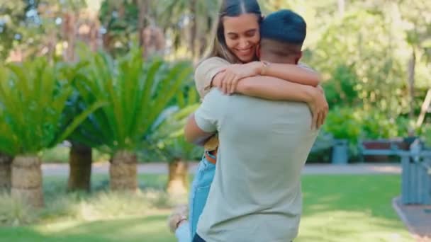 Love, reunion and interracial couple in park hug, smile and happy together in nature on summer weekend. Happiness, man and woman in garden sun, bonding embrace and support with trust in relationship - Footage, Video