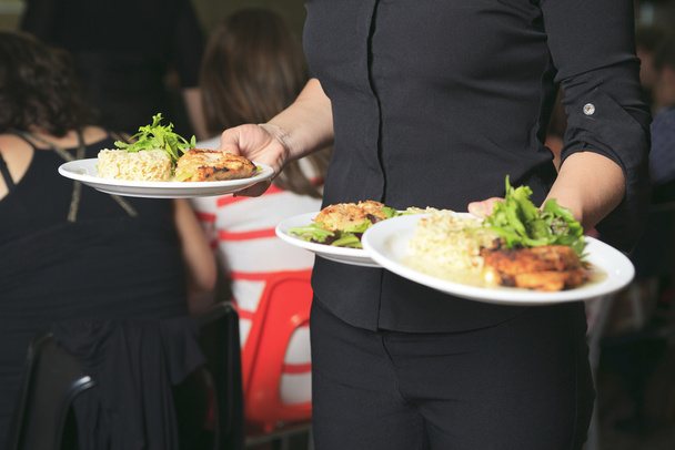 Молодая официантка с тарелкой на руке
 - Фото, изображение
