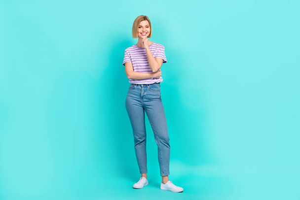 Full body cadre of young thoughtful girl touch chin wear jeans with t-shirt hmm which product should buy isolated on cyan color background. - Фото, зображення