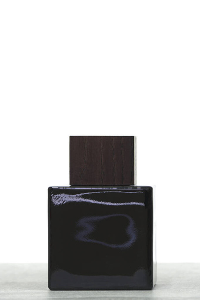 Black glass perfume bottle with wooden lid white background - Photo, Image
