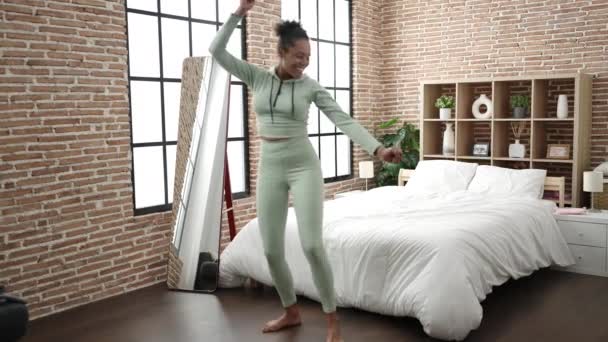 Mujer afroamericana sonriendo confiada bailando en el dormitorio - Imágenes, Vídeo
