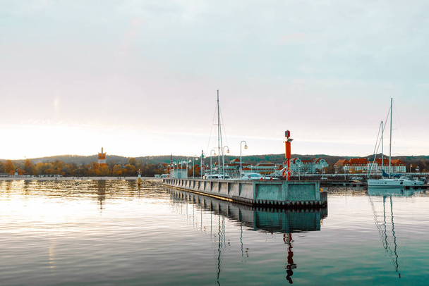ポーランドのソフト- 2022年10月13日:夕日の海港に停泊する豪華なヨット。近代的なモーターボートや青い水の海洋駐車場。静けさ、リラクゼーション、ファッショナブルな休暇。高品質の写真 - 写真・画像