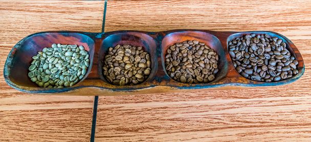 A top down view of dried, light roasted, medium roasted and dark roasted coffee beans in La Fortuna, Costa Rica during the dry season - Photo, Image