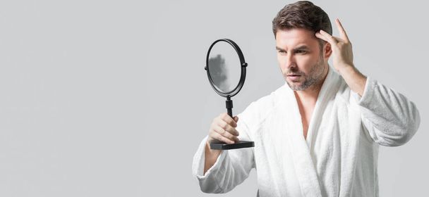 Banner with copy space of man touching chin and skin. Handsome man touching face in front of the mirror in bath. Perfect skin. Man cosmetic, skin treatment. Hygiene and skin care male face - Photo, image