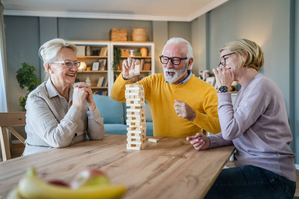 Ryhmä eläkeläisiä mies ja nainen aviomies ja vaimo ystävät tai perhe pelata vapaa lautapeli kotona hauskaa eläkeläinen isoisä ja isoäiti viettää aikaa yhdessä kypsä tytär - Valokuva, kuva