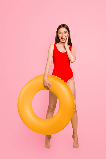 Vertical photo portrait of fit slim with matte colorful lipstick fit slim shouting beautiful lady standing on tiptoes holding big transparent lifebuyo in hand isolated bright vivid background. - Zdjęcie, obraz
