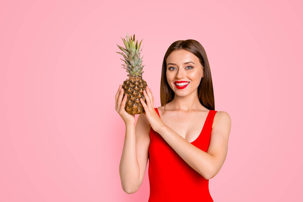 Beach style Charming girl holding a pineapple in her hands isolated on bright yellow background. - Фото, зображення