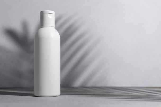 Natural organic cosmetic white bottle mock up with shadow palm leaves. Spa and wellness concept. - Photo, image