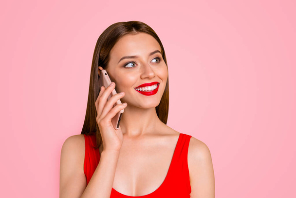 Close up portrait of charming and lovely girl with bright red lipstick on her lips talking on the phone on vacation isolated on yellow background. - Foto, Imagem