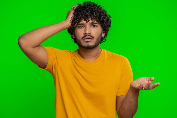 Bearded indian man feeling hopelessness loneliness, nervous breakdown, loses becoming surprised by lottery results, bad fortune, loss, unlucky news. Hindu young guy isolated on chroma key background - Photo, image