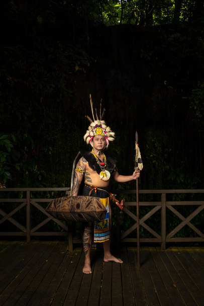 Geleneksel kıyafetlerin içinde zarif bir zarafet: Bir Borneo erkeği geleneksel kıyafetleriyle kültürünün güzelliğini sergiliyor. - Fotoğraf, Görsel