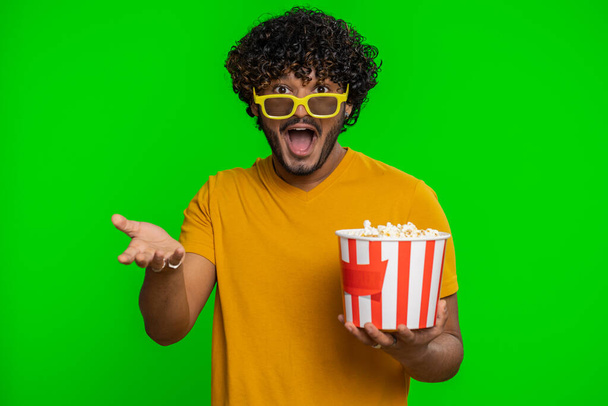 Excited indian man in 3D glasses eating popcorn, watching interesting tv serial, sport game, film, online social media movie content. Hindu guy enjoying domestic entertainment on chroma key background - Foto, immagini