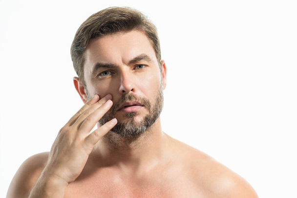 Beauty close up portrait of handsome man with moisturizing cream on face, isolated background. Skincare routine concept. Male haircut, mustache and beard. Male beauty. Shaving, hair styling - Valokuva, kuva