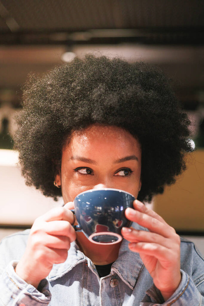 afro nő kezében egy csésze kávé, nagy mosoly, közelkép portré. Kiváló minőségű fénykép - Fotó, kép