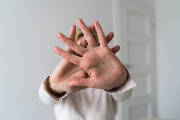 Mujer mostrando gesto de alto con la mano en casa. Abuso, salud mental, problemas de relación tóxica. Foto de alta calidad - Foto, imagen