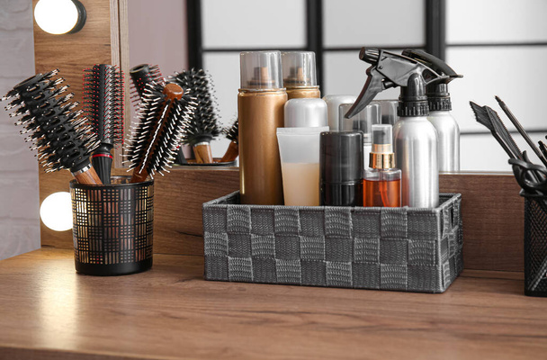 Organizadores con diferentes aerosoles para el cabello y cepillos en la mesa en el salón de belleza - Foto, imagen