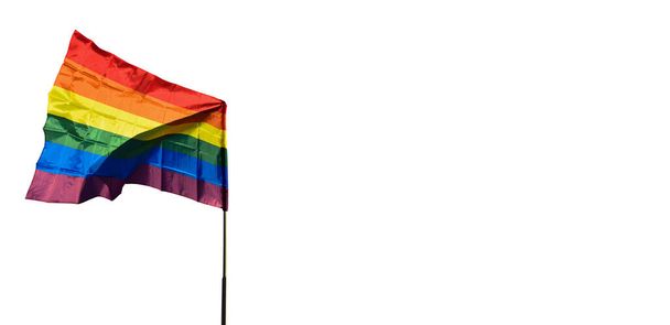 Tęczowa flaga na drewnianym słupie z zachmurzonym i niebieskim tłem, koncepcja dla dumnego miesiąca LGBT na całym świecie. - Zdjęcie, obraz
