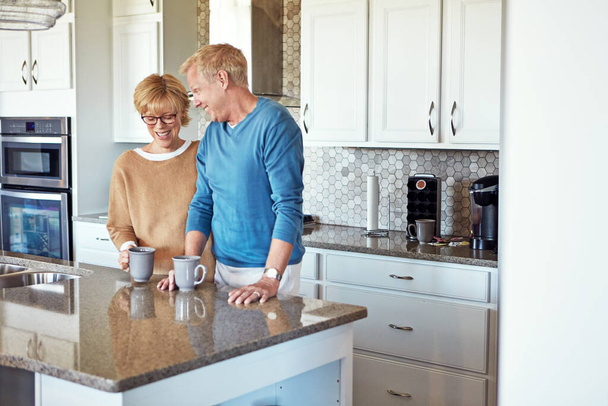 Они единственные в своем роде. зрелая пара пьет кофе на кухне - Фото, изображение