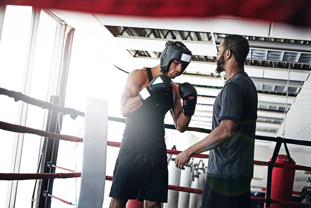 Coaching the next world champion. a man training in the boxing ring with a coach - Foto, Imagen
