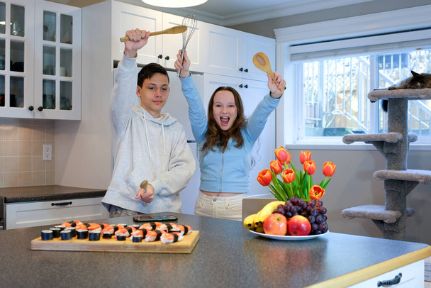 Overjoyed young Caucasian couple dancing singing preparing healthy food together in kitchen, happy millennial husband and wife have fun preparing food enjoy lazy leisure family weekend - Photo, Image