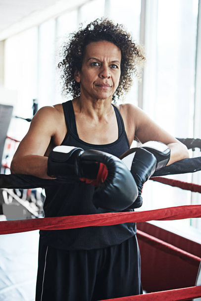 Η στάση είναι η διαφορά μεταξύ πάλης και νίκης. Πορτραίτο μιας ώριμης γυναίκας που εκπαιδεύεται σε ρινγκ πυγμαχίας - Φωτογραφία, εικόνα