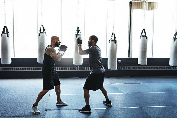Encaixe-se. um boxeador masculino praticando seus movimentos com seu treinador - Foto, Imagem