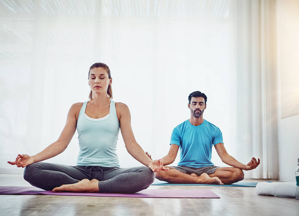 Apprendre à lâcher prise et expérimenter l'intimité. un couple pratiquant le yoga à la maison - Photo, image