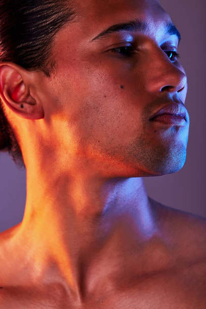 Beauty, neon and face of man in studio for skincare, self care and facial treatment on purple background. Creative aesthetic, glow and profile of male model for healthy skin, wellness and confidence. - Fotografie, Obrázek